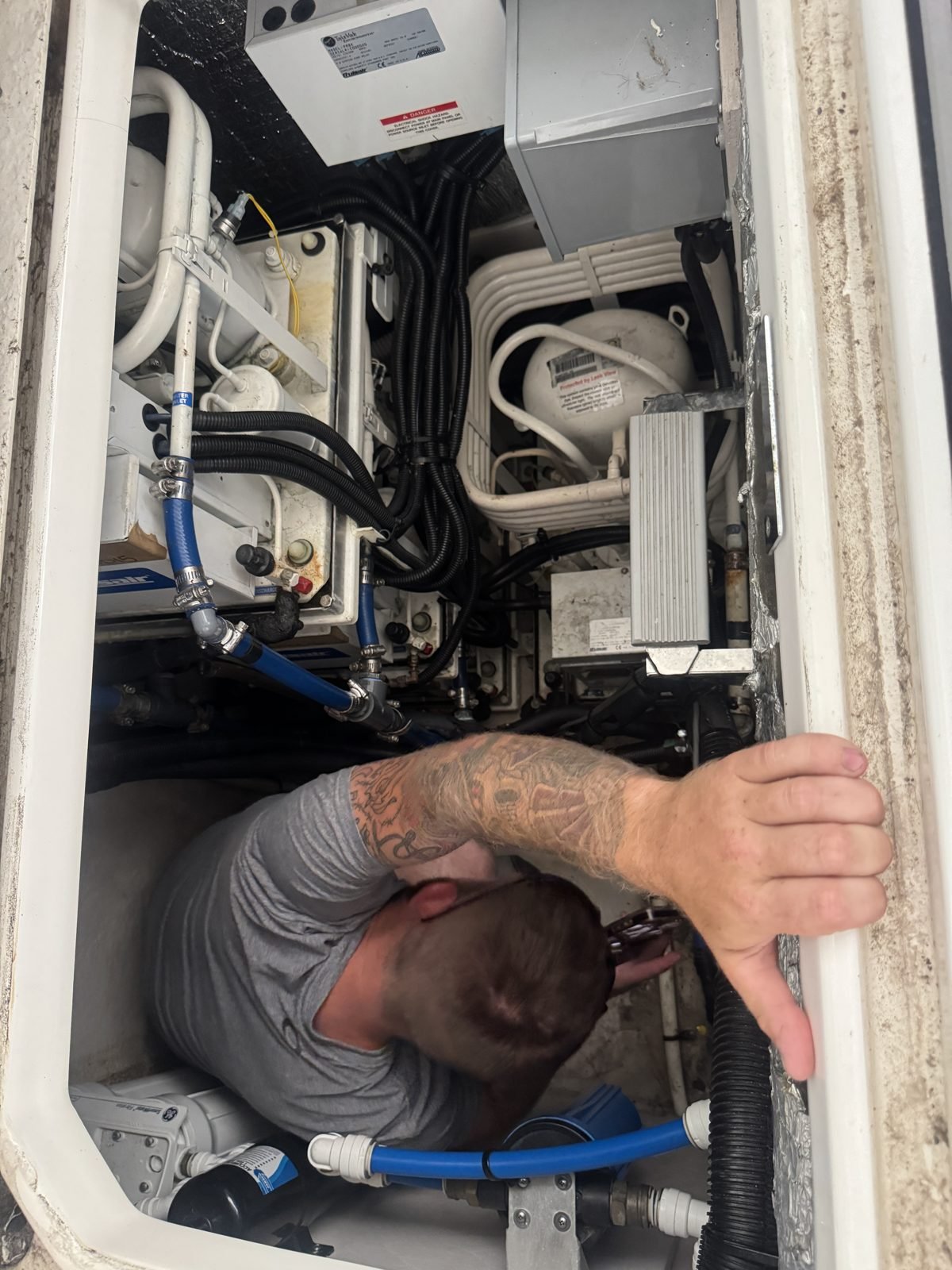Technician servicing a marine air conditioning unit aboard the boat