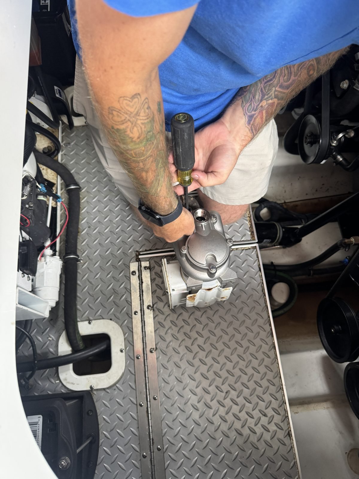 Marine HVAC technician servicing a boat air conditioning compressor dockside